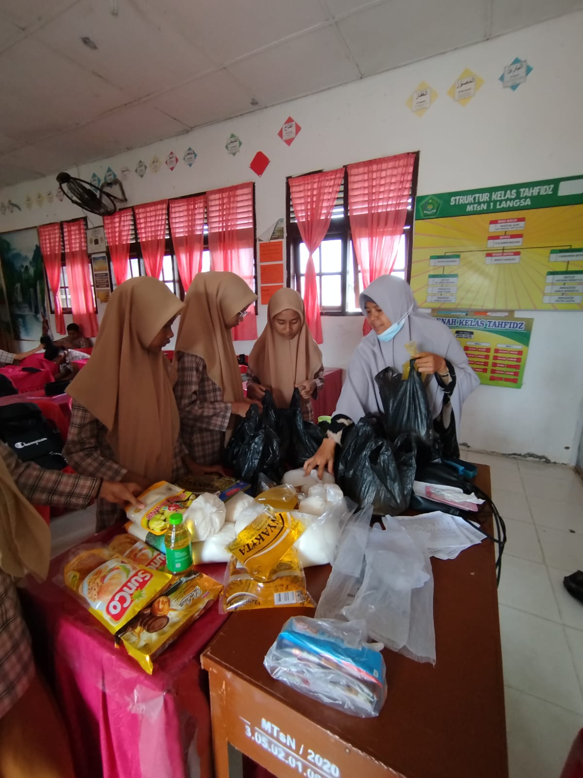 siswa di pandu guru mengumpulkan sembako untuk disedekahkan dan di hadiahkan